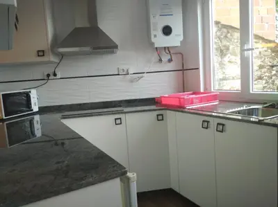 a kitchen with white cabinets and a counter top at Vivienda A Travesía Dos Soños in Sarria