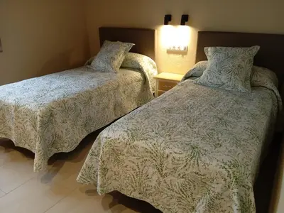 two beds sitting next to each other in a room at O Lar do Alecrín in Friol