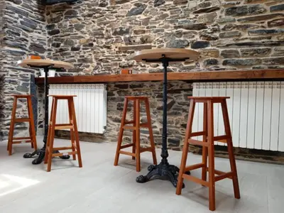three bar stools in front of a stone wall at O Lar do Alecrín in Friol