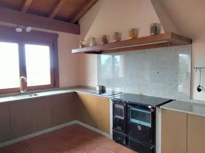 a kitchen with a black stove and a window at Lobetios - Casa rural in Parada de Achas
