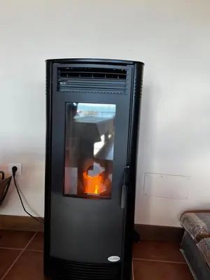 a black oven with a fire inside of it at Lobetios - Casa rural in Parada de Achas
