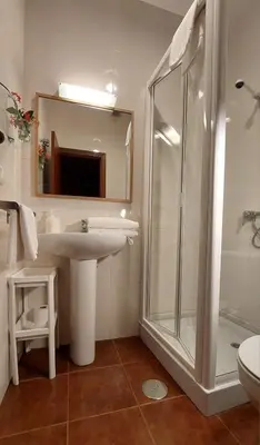a bedroom with a bed and a chair at Casa Rural Maria in Molinaseca