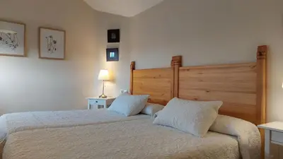 a bedroom with a large bed and a chair at Casa Rural Maria in Molinaseca