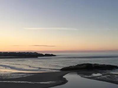 a view of the beach at sunset at Apartamento con hermosas vistas a la playa del Altar in Sieiro