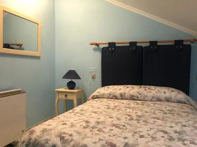 a bedroom with a bed with a black headboard and a mirror at Apartamento con hermosas vistas a la playa del Altar in Sieiro