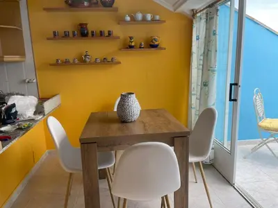 a dining room with a wooden table and white chairs at Apartamento con hermosas vistas a la playa del Altar in Sieiro