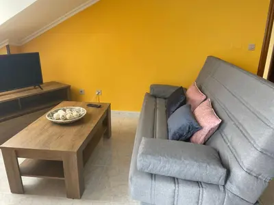 a living room with a couch and a coffee table at Apartamento con hermosas vistas a la playa del Altar in Sieiro