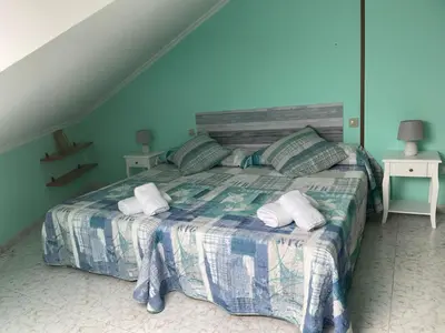 a bedroom with a bed with two towels on it at Apartamento con hermosas vistas a la playa del Altar in Sieiro