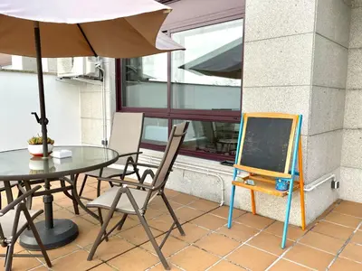 a table and chairs with a table and an umbrella at Estudio céntrico 1 con terraza y parking privado in Ourense