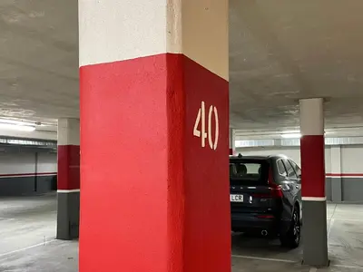a red and white column in a parking garage with a car at Estudio céntrico 1 con terraza y parking privado in Ourense