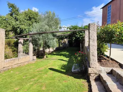 a garden with an arch and some grass and trees at Exclusiva Casa Rural Mariano con acceso directo al rio in Baralla