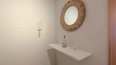 a bathroom with a mirror and a white sink at Apartamento en Miño in A Coruña