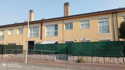 a building with a green fence in front of it at Apartamento en Miño in A Coruña