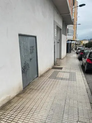 a door on the side of a building with parked cars at Apartamento vacacional foz in Foz