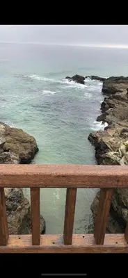 a view of the ocean from a wooden bench at Apartamento vacacional foz in Foz