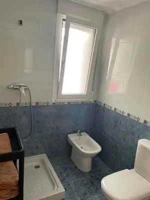 a bathroom with a sink and a toilet and a window at Apartamento vacacional foz in Foz