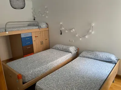 a bedroom with two beds and a bunk bed at Apartamento vacacional foz in Foz