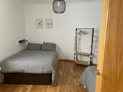 a small bedroom with a bed and a wooden floor at Apartamento vacacional foz in Foz