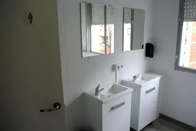 a white bathroom with two sinks and a mirror at Albergue Trabazo in Silleda