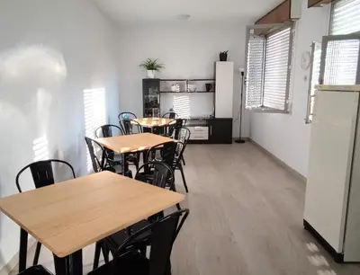 a room with tables and chairs and a refrigerator at Albergue Trabazo in Silleda