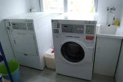 a laundry room with a washing machine and a sink at Albergue Trabazo in Silleda