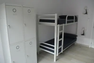 a room with a bunk bed and a ladder and cabinets at Albergue Trabazo in Silleda
