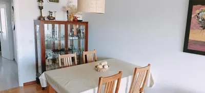 a dining room table with chairs and a glass cabinet at Piso luminoso y acogedor en primera línea de playa Covas Viveiro in Vivero