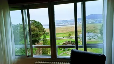 a room with a window with a view of a field at Piso luminoso y acogedor en primera línea de playa Covas Viveiro in Vivero
