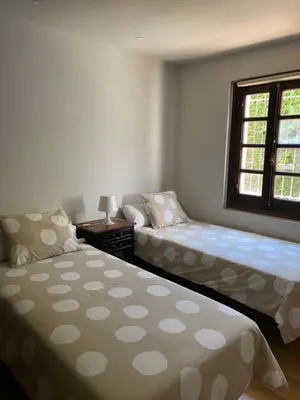 a bedroom with two beds and a window at Agradable chalet rústico in Cambre