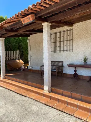 a wooden pergola with a table and bench on a patio at Agradable chalet rústico in Cambre