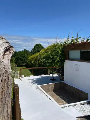 a house with a stone patio with a tree at Casita rústica in Cambre