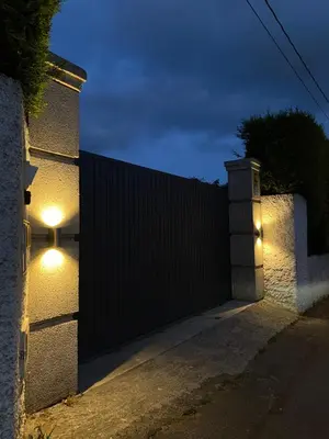 a gate with lights on the side of a house at Casita rústica in Cambre