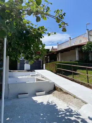 a tree in front of a building with a fence at Casita rústica in Cambre