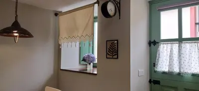 a room with a window and a mirror and a vase of flowers at Casiña d'afreita in Rinlo