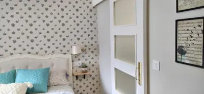 a bedroom with a bed with blue pillows and a wall at Casiña d'afreita in Rinlo
