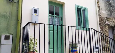 a green door on a house with a fence at Casiña d'afreita in Rinlo
