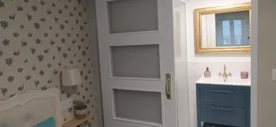 a bathroom with a door with a sink and a mirror at Casiña d'afreita in Rinlo