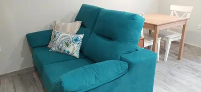 a blue couch in a living room with a table at Casiña d'afreita in Rinlo
