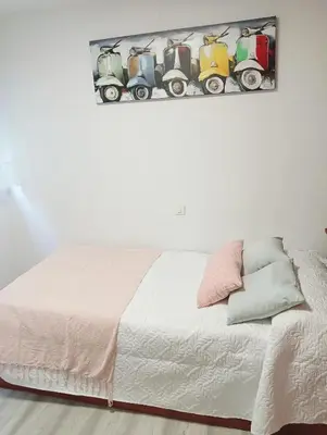 a bedroom with a white bed with a white bedspread at Apartamento Ría Navia in Navia