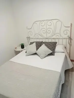 a bedroom with a white bed with pillows on it at Apartamento Ría Navia in Navia