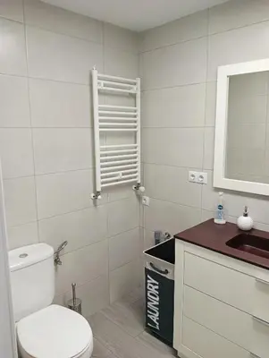 a bathroom with a toilet and a sink and a mirror at Apartamento Ría Navia in Navia