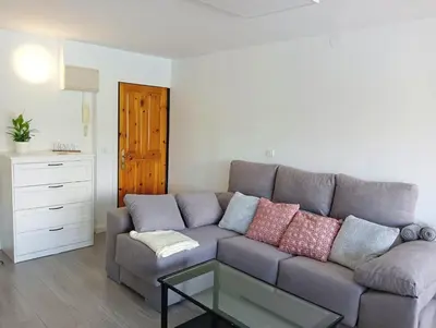 a living room with a gray couch and a glass table at Apartamento Ría Navia in Navia