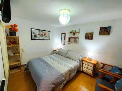 a bedroom with a bed and a table and a chair at Casa das Peleteiro Ribeira Sacra in Ourense