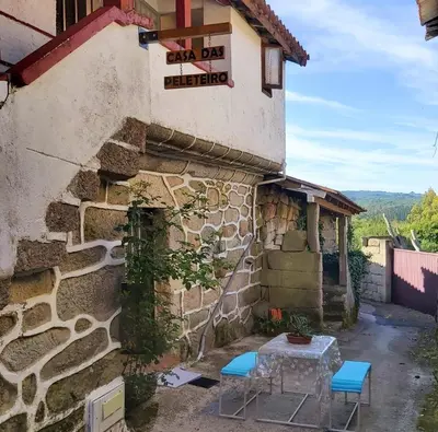 a building with two chairs and a table outside at Casa das Peleteiro Ribeira Sacra in Ourense