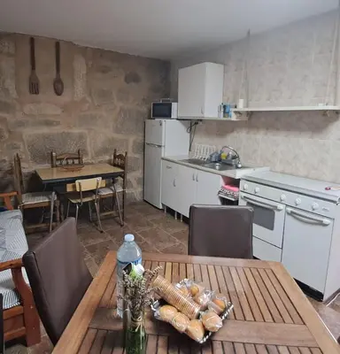 a kitchen and dining room with a table and a kitchen and a table and chairs at Casa das Peleteiro Ribeira Sacra in Ourense