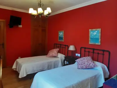 two beds in a room with red walls at Casa Rural dos Chaos in Arnoia