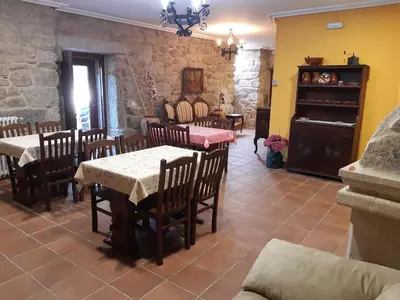 a dining room with tables and chairs and a fireplace at Casa Rural dos Chaos in Arnoia