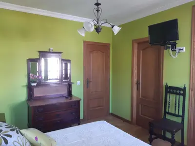 a bedroom with a bed and a dresser and a tv at Casa Rural dos Chaos in Arnoia