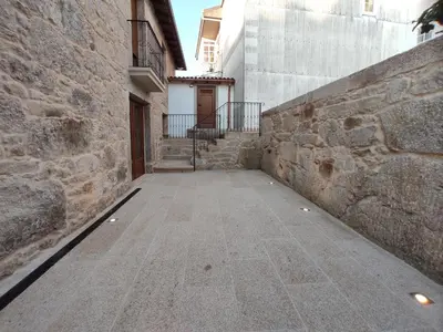 an alley with a stone wall and a building at Casa Lagarto, (Ribeira Sacra), Taboada in Taboada