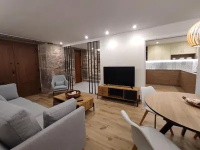 a living room with a television and a table and chairs at Casa Lagarto, (Ribeira Sacra), Taboada in Taboada